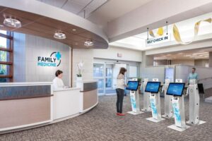 Area lobi klinik Family Medicine dengan beberapa kios self check-in dan meja resepsionis